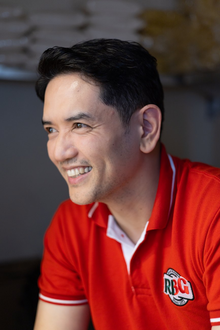 Portrait of Glenn Razon, smiling, in a red polo shirt.