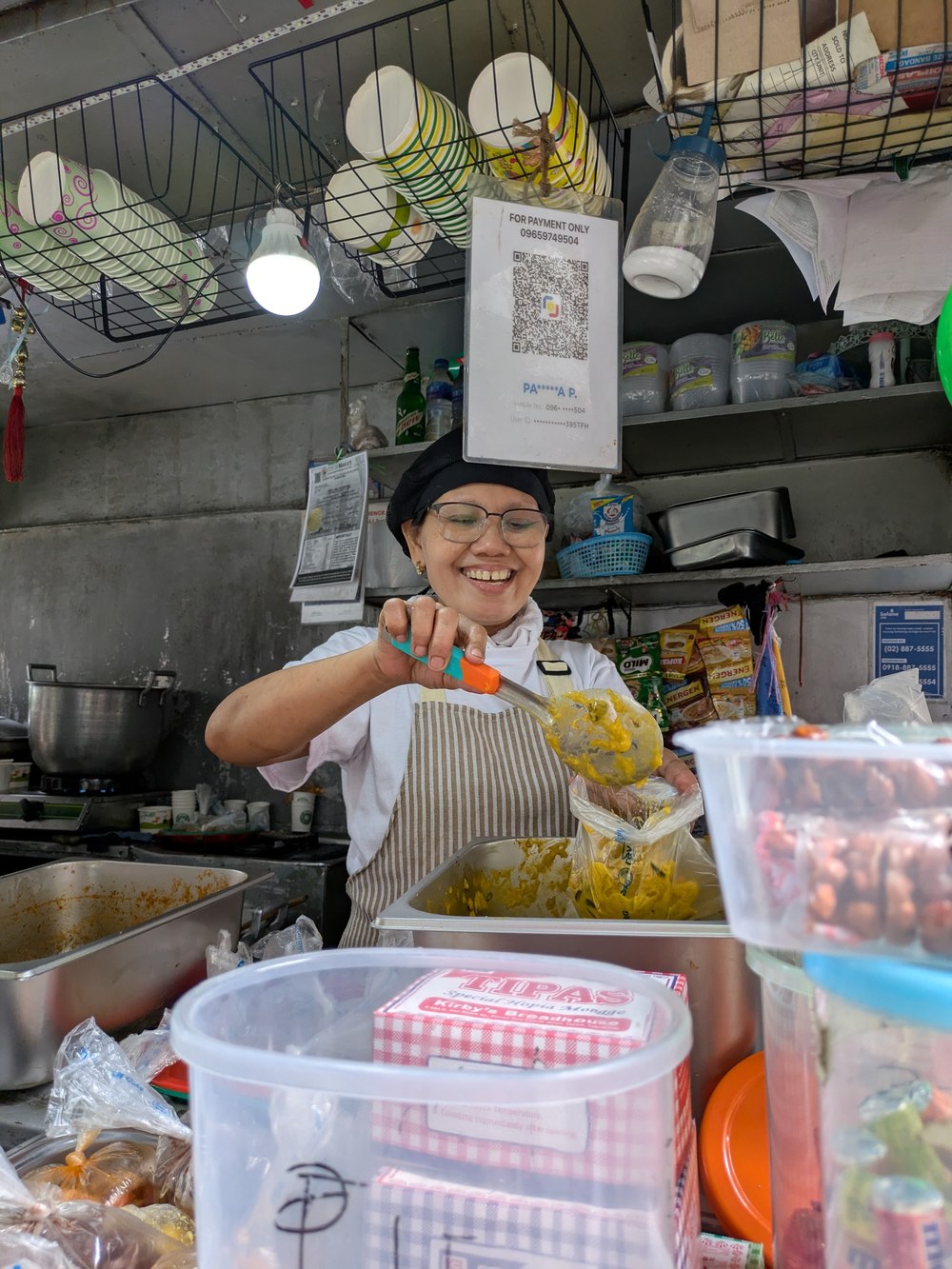 A cook scooping Bicol Express into a plastic bag at a Legazpi Village jollijeep.