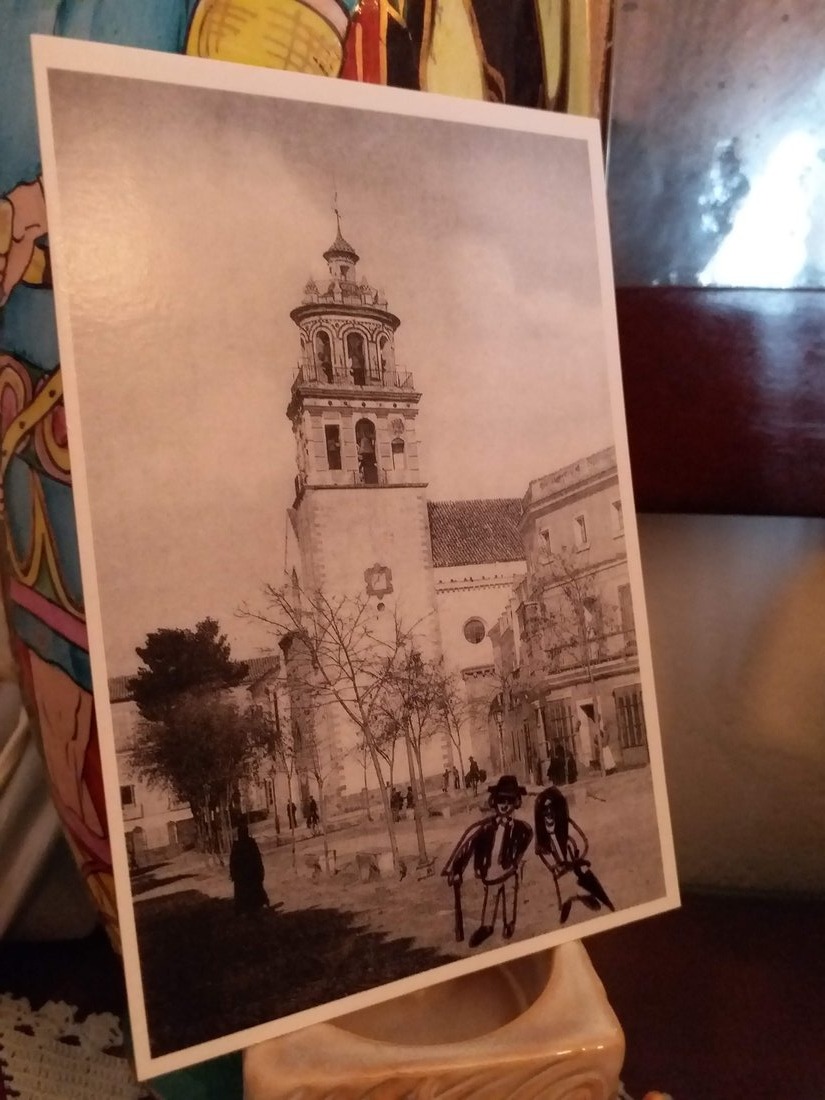 A hand-drawn illustration of the two of them added onto an old sepia postcard of a church bell tower.