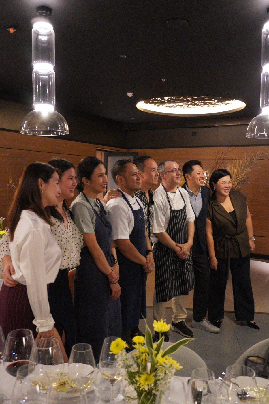 A lineup of chefs, kitchen staff, and guests from the Common Ground dinner, smiling together at the end of the night.
